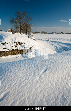 Schneebedeckte Roman Wall mit Blick auf St. Mary die Jungfrau Kirche, geht, Hampshire, Uk Stockfoto