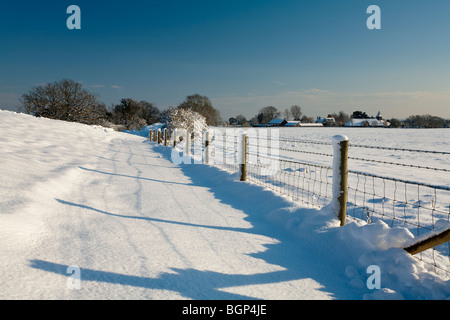 Schneebedeckte Roman Wall mit Blick auf St. Mary die Jungfrau Kirche, geht, Hampshire, Uk Stockfoto