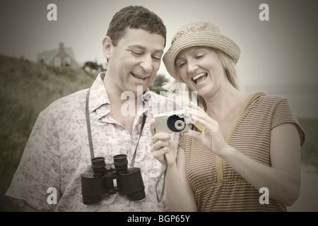 Mitte Erwachsene Frau mit einem reifen Mann stehen und halten Sie eine digitale Kamera Stockfoto