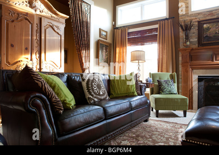 DETAIL AUS EINEM WOHNZIMMER MIT LEDERSOFA UND COUCHTISCH EIN STOFF GEPOLSTERTE SESSEL UND EIN TV-SCHRANK Stockfoto