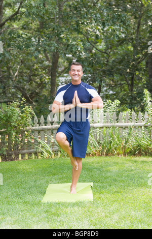 Reifer Mann üben von Yoga in einer Baumpose Stockfoto