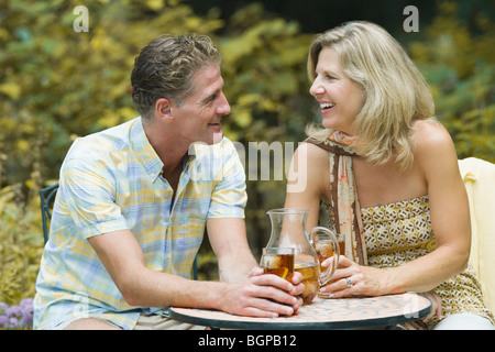 Älteres Paar an einem Tisch sitzen und halten Glas Eistee Stockfoto