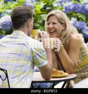 Älteres Paar mit Tee in einem Rasen und lachen Stockfoto