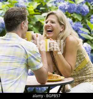 Älteres Paar mit Tee in einem Rasen und lachen Stockfoto