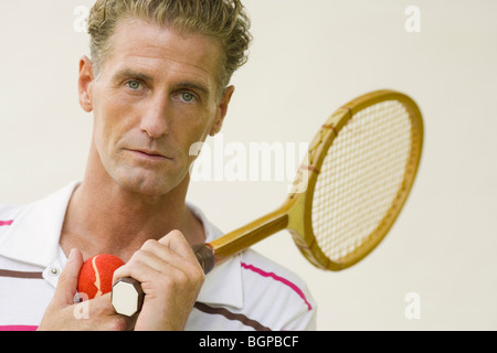 Porträt von einem reifen Mann hält einen Tennisschläger und Tennisbälle Stockfoto