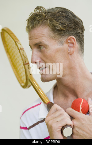 Nahaufnahme von einem reifen Mann hält einen Tennisschläger und Tennisbälle Stockfoto