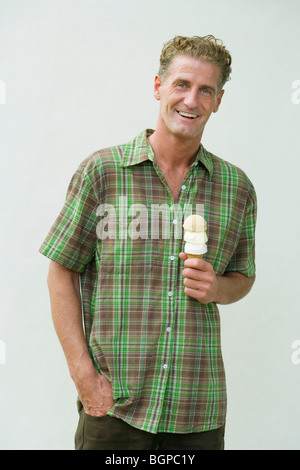 Porträt von einem reifen Mann hält eine Eiswaffel Stockfoto