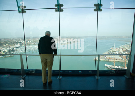 Ein Mann blickt auf Portsmouth Harbour von der Aussichtsplattform des Spinnaker Tower, Portsmouth. Stockfoto