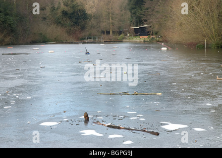 Die berühmten gemischt Teich in Hampstead Heath ist während einer Kältewelle im Winter eingefroren. Die Anlegestelle menschenleer ist. Stockfoto