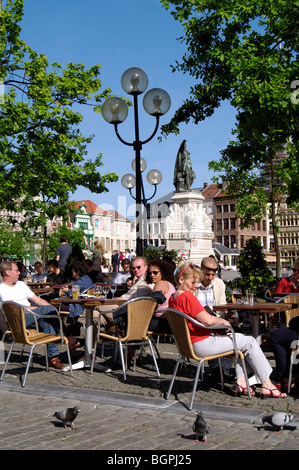 Touristen sitzen in einem Straßencafé auf dem Freitagsmarkt / Vrijdagmarkt in Gent, Belgien Stockfoto