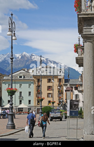 Mann und Frau zu Fuß in Plaza Emilio Chanoux mit Rathaus rechts in Aosta Italien Gran Paradiso Hochgebirge in Ferne Stockfoto