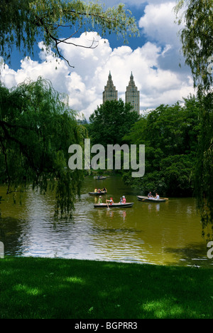 Ruderboote am See im Central Park, in der Nähe von das Bootshaus mit der New Yorker Skyline im Hintergrund. Stockfoto