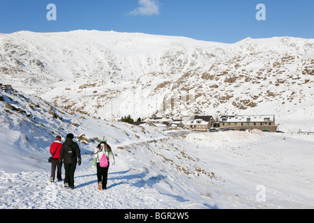 Menschen zu Fuß auf Bergleute Track von Pen-y-Pass YHA mit Schnee auf den Bergen im Nationalpark Snowdonia (Eryri) im Winter 2010. Gwynedd, Wales, Großbritannien Stockfoto