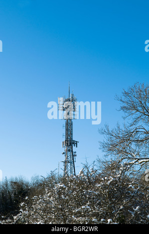 Handy-Mast mit Schnee vor blauem Himmel. Gelegen in der Nähe von Stroud in Cotswolds. Stockfoto