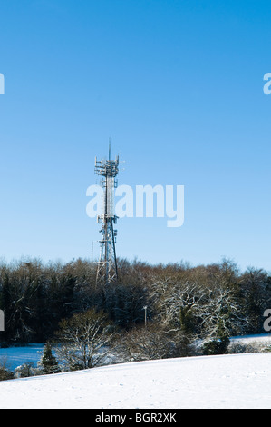 Handy-Mast mit Schnee vor blauem Himmel. Gelegen in der Nähe von Stroud in Cotswolds. Stockfoto