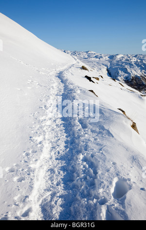 Spuren im Tiefschnee unterwegs Bergleute nach starkem Schneefall in den Bergen des Snowdonia National Park, North Wales UK. Stockfoto