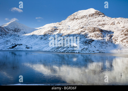 Blick über Llyn Cronfa Llydaw (Behälter) zu Krippe Goch und Mt Snowdon mit Schnee im Winter. Snowdonia National Park (Eryri), North Wales UK Großbritannien Stockfoto