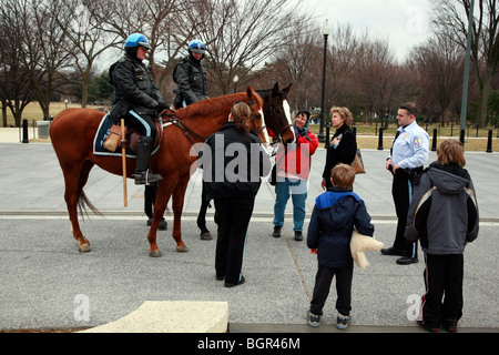 Menschen im Gespräch mit zwei berittene Polizisten auf dem Pferderücken in Washington, D.C., Hauptstadt der Vereinigten Staaten von Amerika Stockfoto