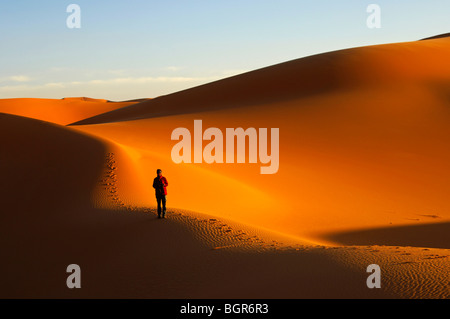 Touristischen Spaziergang bei Sonnenuntergang in den Dünen von Erg Muzuruq, Sahara Wüste, Libyen Stockfoto
