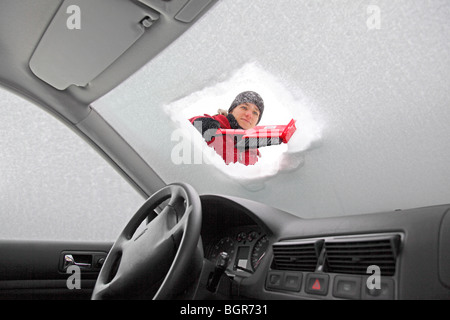 Frau ist die Windschutzscheibe eines Autos aus Schnee und Eis im Winter clearing Stockfoto