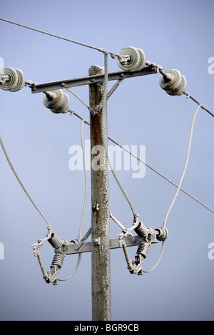 Hölzerne elektrische Pylon mit Eis bedeckt. Stockfoto