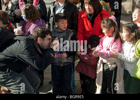 Paris, Frankreich, französischer Fotograf, der chinesische Kinder in Menschenmenge fotografiert, bei der jährlichen Parade im chinesischen Neujahrskarneval in der Straße im Marais-Viertel, Migrantenfamilie, Minderheitenfamilie Immigranten Europa Stockfoto