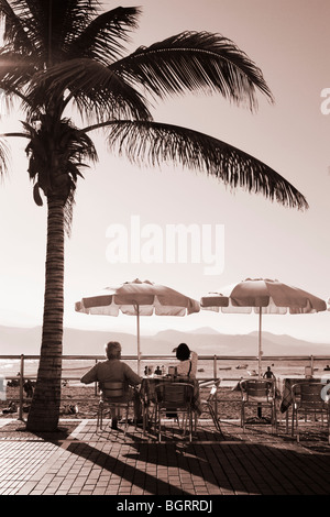 Paar unter Palme an der bar mit Blick auf Strand von Las Canteras in Las Palmas auf Gran Canaria Stockfoto