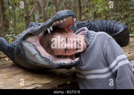 kleiner Junge posiert mit seinem Kopf in ein Modell Alligator an Silver Springs Florida Stockfoto