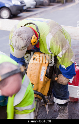 Arbeiter graben Gas Rohrleitungen mit einem Presslufthammer. Stockfoto