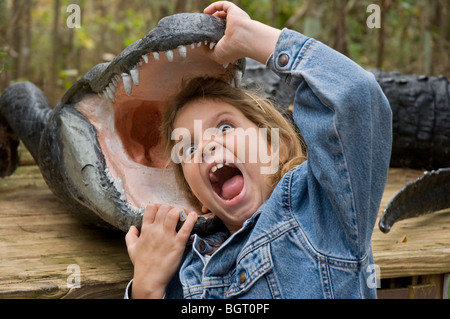 junges Mädchen posiert mit ihrem Kopf in ein Modell Alligator an Silver Springs Florida Stockfoto