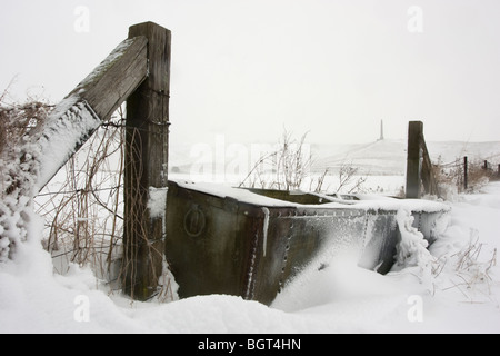 Eine Schnee gebunden Tier Tränke im Schatten von Cherhill White Horse und das Lansdowne Monument William Petty Stockfoto