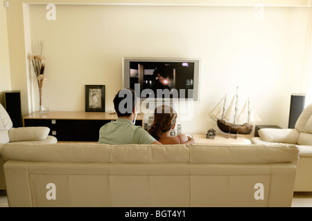 Mann und Frau sitzen auf der Couch vor dem Fernseher Stockfoto