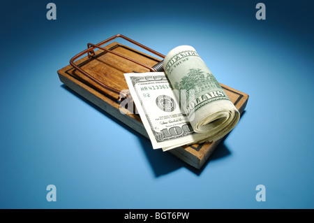 Eine Rolle von Geld sitzt auf einer bewaffneten Mausefalle aus Holz Stockfoto