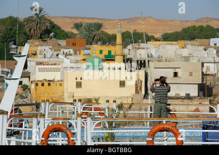 ASWAN, ÄGYPTEN. Ein Mann mit dem Fotografieren von Elephantine Insel vom Deck eine Nil-Kreuzfahrt-Schiff. Stockfoto