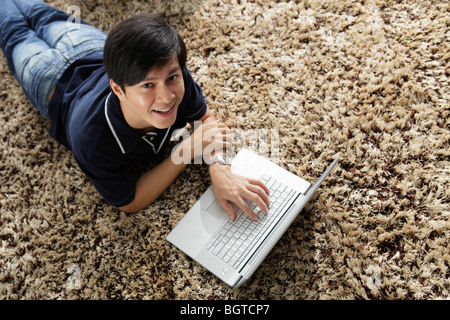 Junger Mann Handauflegen Magen arbeiten am Laptop Stockfoto