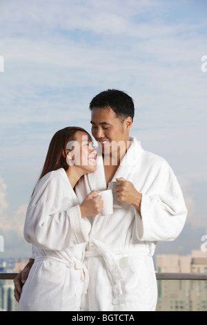 Junges Paar in Roben Lächeln einander an Stockfoto