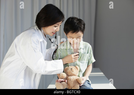 Arzt auf kleiner junge Herz hören. Stockfoto