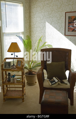 Ein komfortabler Stuhl mit Sonne, durch Fenster Stockfoto