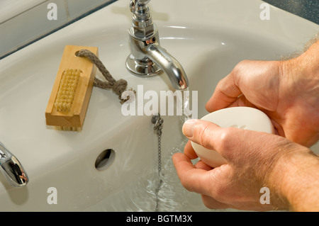 Nahaufnahme eines Mannes, der sich die Hände mit Seife wascht und Wasser Handhygiene Gesundheit im Badezimmer Stockfoto