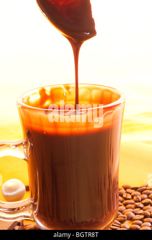 schmackhafte flüssige Schokolade auf Glas Stockfoto