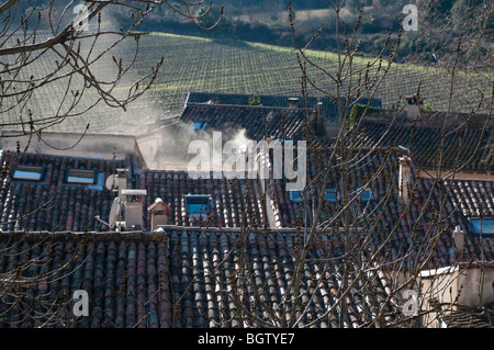 Dächer und Schornstein Rauchen in dem mittelalterlichen Dorf von St Jean de Bueges, Herault, Südfrankreich Stockfoto