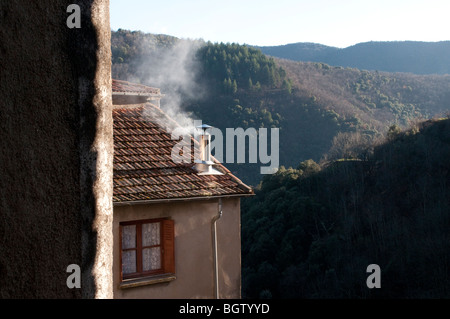 Rauch aus dem Schornstein in einem Haus im Saint Martial, mittelalterliches Dorf im Rieutord-Tal, Gard, Südfrankreich Stockfoto