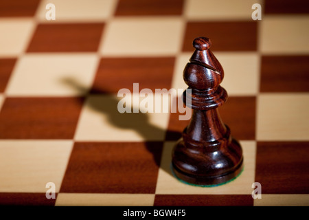 Schachfigur - eine schwarze Läufer auf einem Schachbrett. Stockfoto