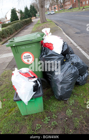 Grüne Wheelie bin überfüllt mit Hausmüll erwartet Sammlung Cheltenham UK Stockfoto