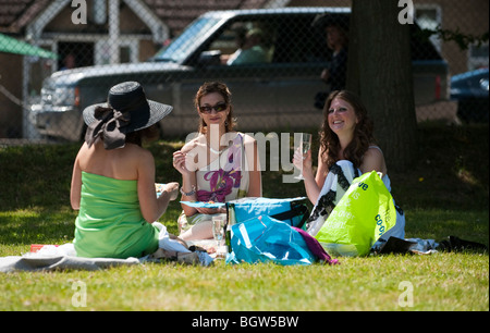 Drei Frauen mit einem Picknick auf dem Rasen im Royal Ascot Stockfoto