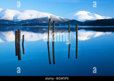 Blick über Derwentwater Schnee verkleidet Skiddaw und Blencathra oder Saddleback und Reste der alten Mole oder Pier Seenplatte Cumbria Stockfoto