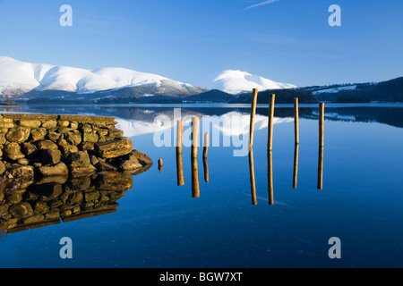 Blick über Derwentwater Schnee verkleidet Skiddaw und Blencathra oder Saddleback und Reste der alten Mole oder Pier Seenplatte Cumbria Stockfoto