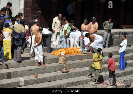 Zeremonielle Vorbereitungen für eine Feuerbestattung an den Ufern des Flusses Bagmati vor dem Pasupatinath Tempel Stockfoto