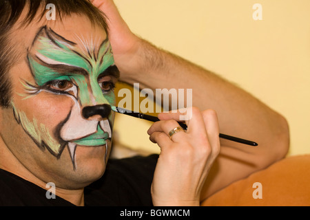 Make-up-Künstler malen das Gesicht des Mannes. Stockfoto