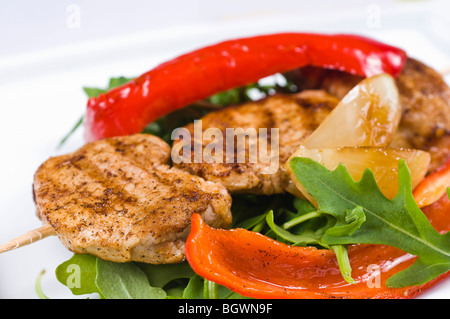 Schweinsmedaillons auf einer Landzunge am gerockt Salat mit gerösteten Paprika und Tomaten Stockfoto